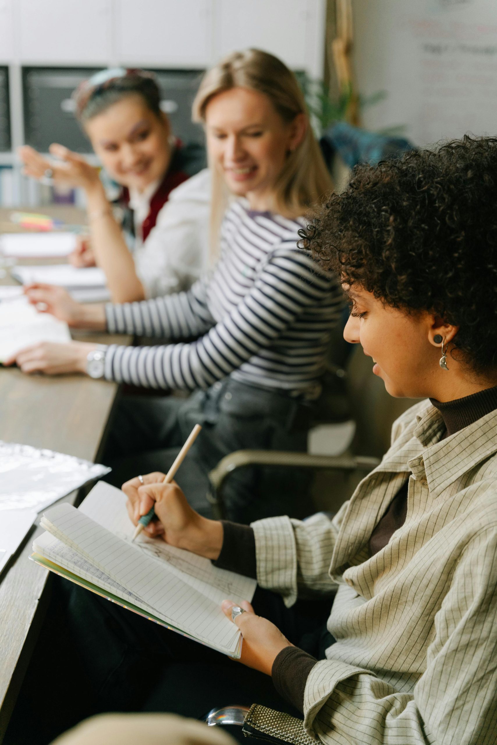 Diverse team brainstorming ideas and taking notes in a collaborative work session.